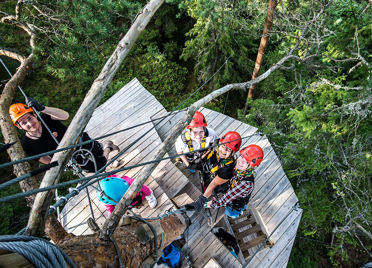 Grupp med människor på zipline-platta